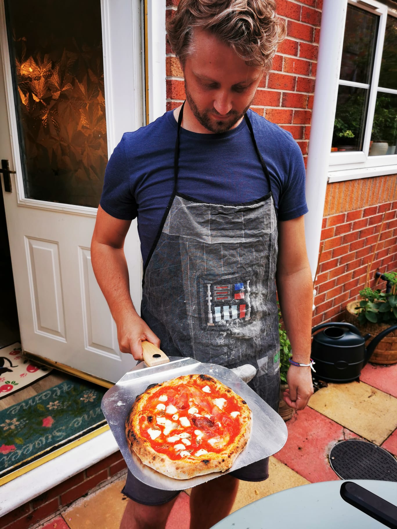 Pizza maker wearing an apron preparing dough